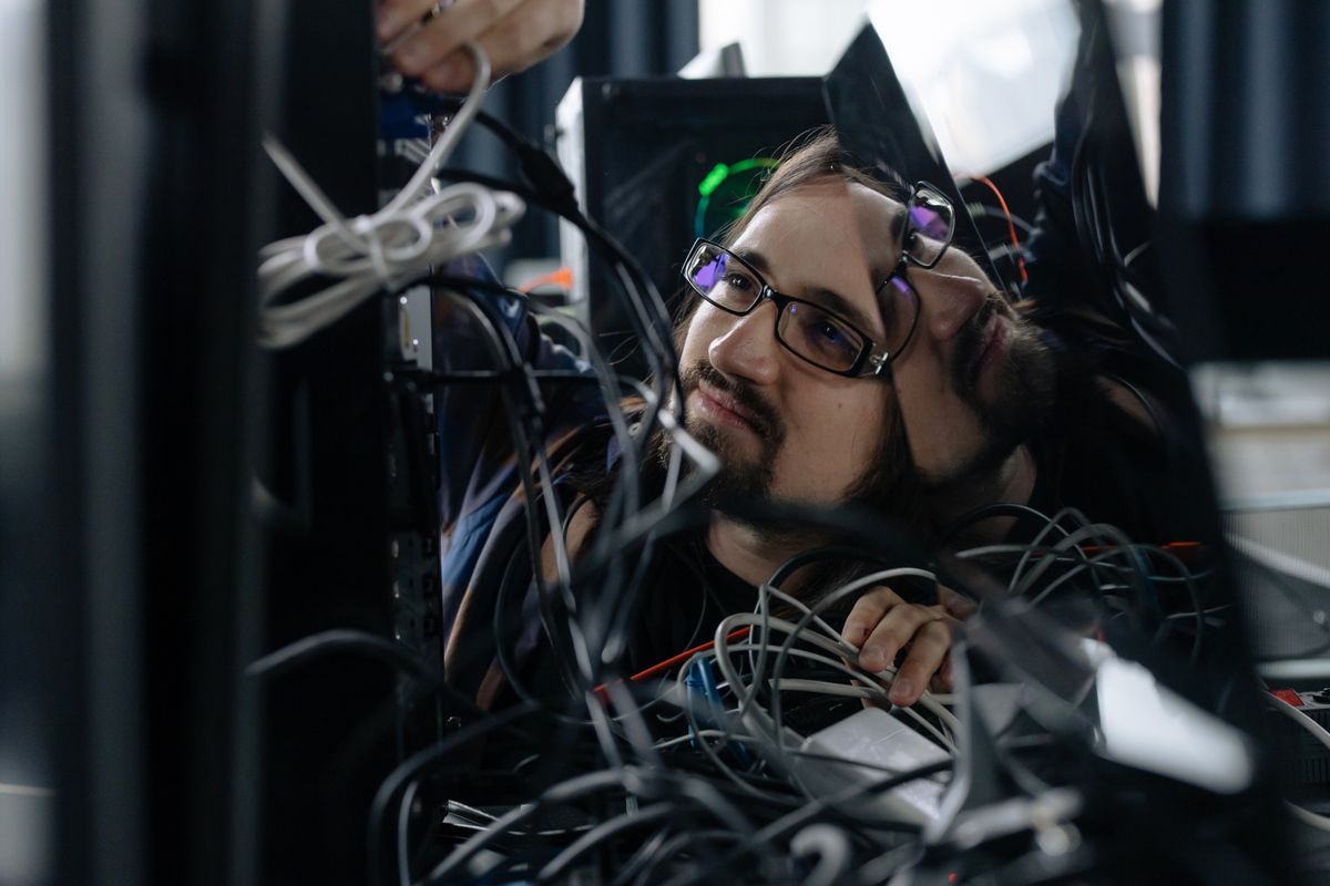 IT technician sorting network cables at a workstation in an office